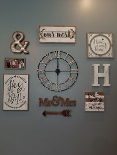 a wall with many different types of signs and clocks hanging on it's side