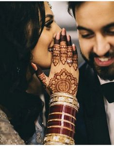 a man and woman holding each other close to one another with their hands painted on