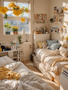 a bedroom with yellow flowers hanging from the ceiling and pictures on the wall above the bed