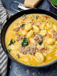 a bowl of pasta and meat soup with spinach