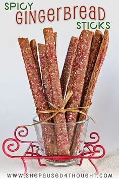 a glass bowl filled with gingerbread sticks on top of a white tablecloth next to a red sign that says spicy gingerbread sticks