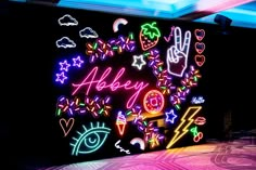 a wall with neon signs and symbols on it