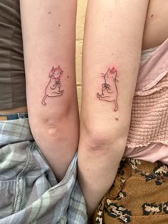 two people with matching tattoos on their arms, one has a cat and the other has a dog