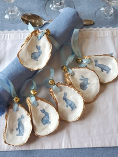 six blue and white porcelain dishes with bunny rabbit designs on them, next to wine glasses