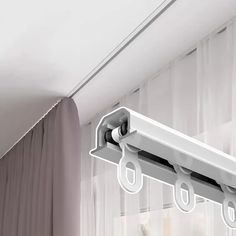 a white curtain is hanging from the side of a window with two hooks on it