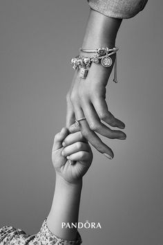 two people holding hands while wearing bracelets