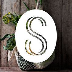 the letter s is made out of wire and sits on top of a wooden table