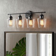 a bathroom vanity light with four lights on it and a mirror in front of it