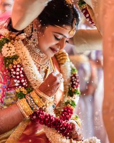 the bride is getting ready to put garland on her head