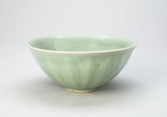 a green bowl sitting on top of a white table