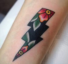 a tattoo on the arm of a woman with an arrow and flowers in its center