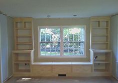 an empty room with bookshelves and windows