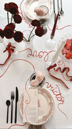 a table set for valentine's day with red roses