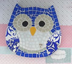 a blue and white plate with an owl on it's face, sitting on a table