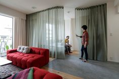 two people are standing in the living room and one person is on a skateboard