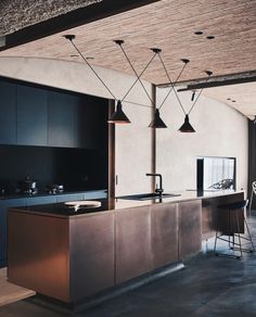 a kitchen with an island and bar stools next to the counter top in front of it