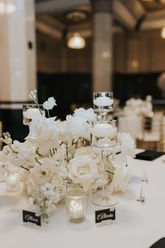 white flowers and candles are sitting on a table