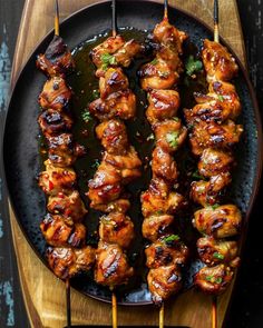 chicken skewers are being served on a plate with toothpicks in them