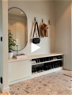 there is a coat rack with shoes on it and a mirror above the shoe rack