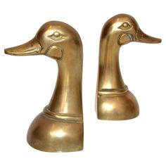 two brass colored ducks sitting next to each other