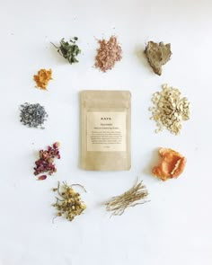 an assortment of herbs and powders laid out on a white surface