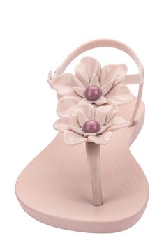 Dimensional floral details blossom on a glossy sandal complete with a sleek thong strap. Adjustable ankle strap Synthetic upper, lining and sole Made in Brazil Hispanic & Latinx Owned/Founded Elegant Beach T-strap Sandals With Adjustable Strap, Adjustable Flower Sandals For Spring, Elegant Flat Jelly Sandals For Spring, Elegant Summer Jelly Sandals With Ankle Strap, Feminine Synthetic Sandals For The Beach, Elegant Ankle Strap Jelly Sandals For Summer, Spring Flip Flops With Adjustable Strap, Feminine Ankle Strap Sandals For Beach, Elegant Spring Jelly Sandals For Beach