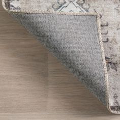 an area rug on the floor that has been placed in front of a wooden surface