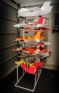 several different types of kites are stacked on top of each other in front of a garage door