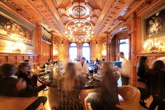 a group of people sitting around a table in a room with wood paneled walls