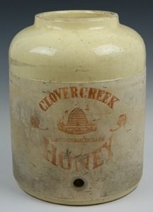 an old white glass jar with some writing on it