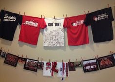 t - shirts hanging on clothesline with pictures and pins pinned to the wall in front of them