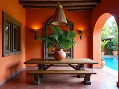 a potted plant sitting on top of a wooden table next to a swimming pool