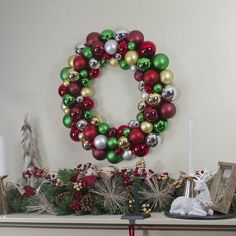 a mantle decorated with christmas decorations and ornaments on it's mantle, including an ornament wreath