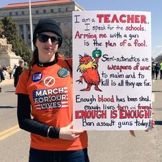 a woman in an orange shirt holding up a sign