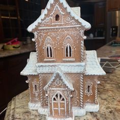 a gingerbread house is sitting on a kitchen counter