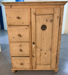 an old wooden armoire with drawers and knobs