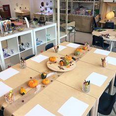 the table is set up with paper, pencils and pumpkins on it for an art class