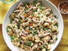 a white bowl filled with pasta and peas