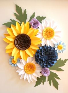 paper flowers made to look like sunflowers and daisies on a white background