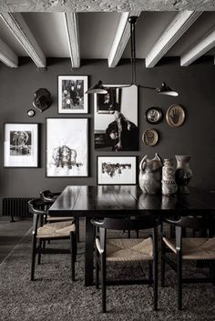 a dining room with black walls and pictures on the wall