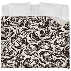 a black and white comforter with swirls on the bed cover, in front of a white background