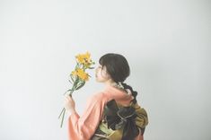 a woman holding flowers up to her face