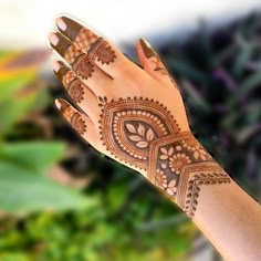 a woman's hand with henna tattoos on it