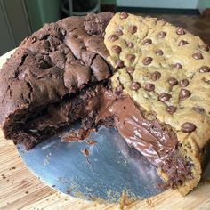 a chocolate chip cookie cake cut in half on a cutting board