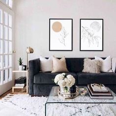 a living room with two pictures on the wall and a coffee table in front of it