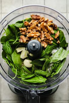 spinach leaves and walnuts in a food processor