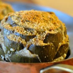 an artichoke in a wooden bowl on a table