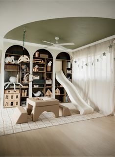 a living room filled with furniture and a slide in the middle of it's walls