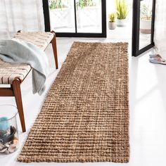 a large rug in the middle of a room with two chairs and a window behind it