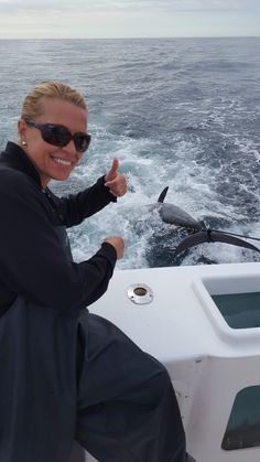 a woman on a boat giving the thumbs up